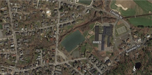 This figure is an aerial photo showing the Manchester Memorial Elementary School and its nearby neighborhood.